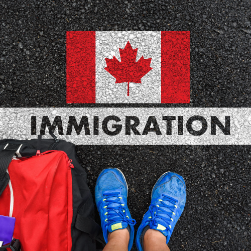 Backpack and shoes beside an IMMIGRATION stencil and Canadian flag on pavement